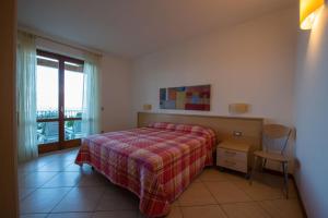 a bedroom with a bed and a window at ApartmentsGarda - Canevini Residence in Torri del Benaco