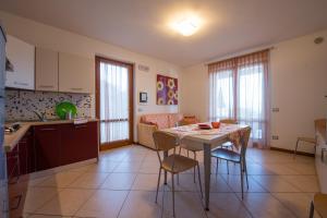 a kitchen and living room with a table and chairs at ApartmentsGarda - Canevini Residence in Torri del Benaco
