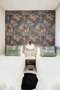 sypialnia z 2 łóżkami i ścianą z tapetą w obiekcie Apartamento alameda w mieście Pontevedra