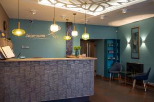 a bar in a lobby with blue walls and lights at Zarechnaya Hotel in Petrozavodsk