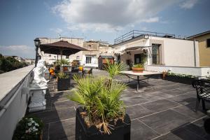 Hotel del Real Orto Botanico في نابولي: فناء مع نباتات الفخار وطاولة على السطح