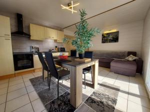 a kitchen and living room with a table and chairs at Entre lac et montagne, proche centre de St Jorioz, spacieux et confortable appartement avec grande terrasse in Saint-Jorioz