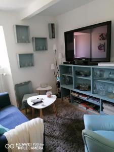a living room with a large flat screen tv at GÎTE AU TILLEUL pour 8 personnes in Mariac