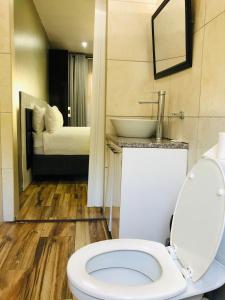 La salle de bains est pourvue de toilettes blanches et d'un lavabo. dans l'établissement Angel Guest House, à Johannesbourg