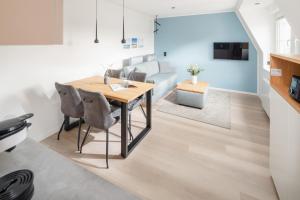 ein Esszimmer und ein Wohnzimmer mit Tisch und Stühlen in der Unterkunft Urlaubs-Residenz Norderney in Norderney