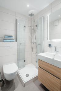 ein Badezimmer mit Dusche, Toilette und Waschbecken in der Unterkunft Urlaubs-Residenz Norderney in Norderney + 14 Fotos