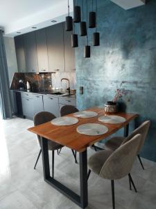 una mesa de madera en una cocina con sillas alrededor en Apartament Blue Sky, en Lubin