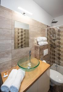 a bathroom with a glass sink and a toilet at City Panzió in Szarvas