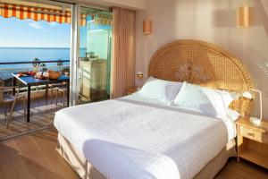 um quarto com uma cama grande e vista para o oceano em Super Cannes Sea Side em Vallauris