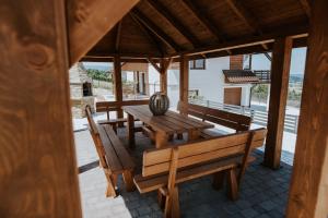 a wooden table and benches on a patio at Wzgórze Marzeń in Zembrzyce