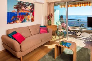 uma sala de estar com um sofá e vista para o oceano em Super Cannes Sea Side em Vallauris