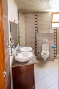 a bathroom with two sinks and a toilet at Luxury 3BR Nyali Beachfront Apartment - 3 Min Walk in Mombasa