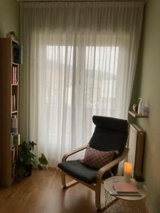 a living room with a chair and a window at Adriatico Rooms in Tarvisio