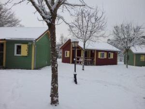 eine Gruppe von Häusern mit Schnee auf dem Boden in der Unterkunft Chalet edelweiss 35 in Mélisey