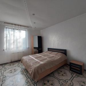 a bedroom with a large bed and a window at Little Shangri-La in Almaty