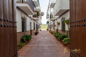 un callejón en un edificio de apartamentos con plantas en Apartamento en Ronda Ocho Caños con Wifi, en Ronda