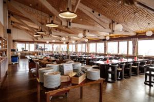 a large dining room with tables and chairs and windows at Köja Fjällhotell in Edsåsdalen