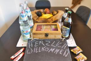 a table with bottles of beer and a box of fruit at Apartment Bavaria - Zentral mit Stellplatz, Küche & Netflix in Pfaffenhofen an der Ilm
