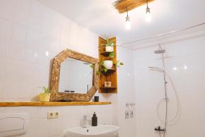 a bathroom with a sink and a mirror at Apartment Bavaria - Zentral mit Stellplatz, Küche & Netflix in Pfaffenhofen an der Ilm +22 photos