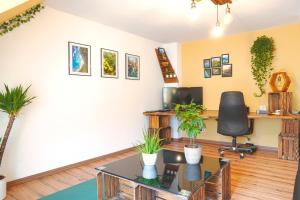 an office with a desk and a table with plants at Apartment Bavaria - Zentral mit Stellplatz, Küche & Netflix in Pfaffenhofen an der Ilm