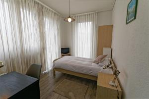 a bedroom with a bed and a desk with a lamp at Les Chambres du CTN in Geneva