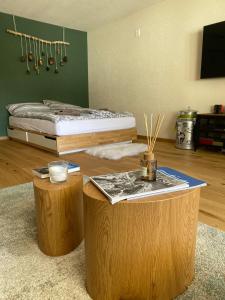 a bedroom with a bed and two tables and two logs at Calarosa Boutique Apartment Arosa in Arosa