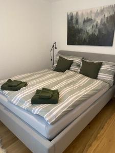 a large bed with two green towels on it at Calarosa Boutique Apartment Arosa in Arosa