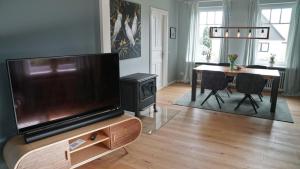 a living room with a television and a dining room table at Maries Haus in Schaalby
