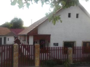 Biały dom z drewnianym płotem i budynkiem w obiekcie Bekecs Vendégház w mieście Nagyvisnyó