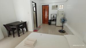 uma sala de estar com uma mesa e um frigorífico em The Palines Apartment and Guesthouse - Vista Alabang em Manila