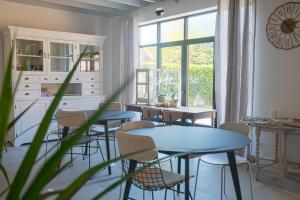 a dining room with tables and chairs and a window at Cire Bed and Breakfast in Meerhout
