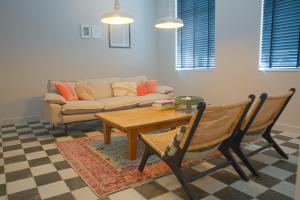 sala de estar con mesa, sillas y sofá en Cire Bed and Breakfast, en Meerhout