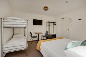 1 Schlafzimmer mit 2 Etagenbetten und einem Schreibtisch in der Unterkunft Hotel de Logerij Renesse in Renesse
