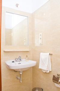 a bathroom with a sink and a mirror at Pensión La Palma in El Puerto de Santa María