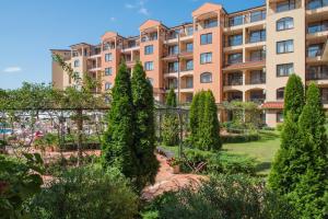 a large apartment building with trees in a garden at Hotel & SPA Diamant Residence - All Inclusive in Sunny Beach