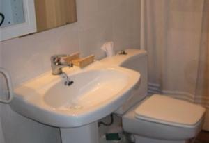a bathroom with a white sink and a toilet at Baywatch Penthouse in Altafulla +9 photos