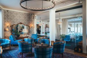 a lobby with blue chairs and a table at Stora Hotellet i Fj&auml;llbacka in Fj&auml;llbacka