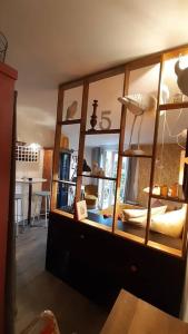 a room with a large wooden cabinet with glass doors at Sauveur le Sculpteur in Talence