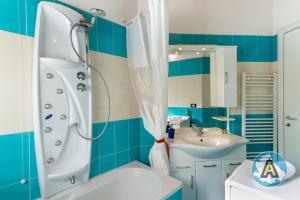 y baño azul y blanco con ducha y lavabo. en Mariquita - Appartamento fronte mare a Silvi, en Silvi Marina