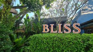 Un segno che dice beatitudine sopra una siepe di Bliss Resort Krabi a Klong Muang Beach