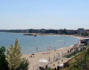 a beach with people on the sand and the water at Victoria's apartments Nesebar in Nesebar
