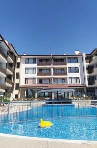 a swimming pool with a yellow object in front of a building at Victoria's apartments Nesebar in Nesebar