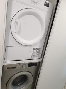 a washing machine with a mirror on top of it at Les Rochettes, joli appartement, tout neuf, calme et paisible in Saint-Gervais-dʼAuvergne