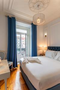 sypialnia z dużym łóżkiem i oknem w obiekcie Solar dos Poetas w Lizbonie