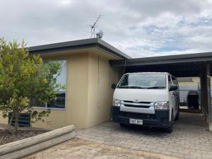 una camioneta blanca estacionada frente a una casa en CandE on Buller, en Kingscote