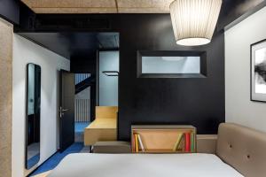 1 dormitorio con cama y pared negra en NUO By juSTa en Nueva Delhi