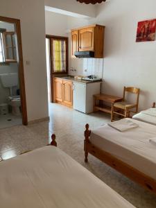 a bedroom with two beds and a kitchen with a sink at Dafni Studios in Neo Klima +42 photos