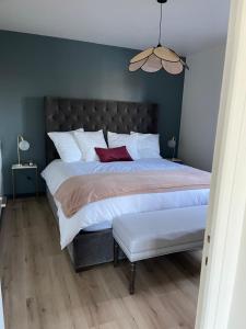 a bedroom with a large bed with white pillows at Ambiance Seine, appartement surplombant la Seine -51 M2, Anémone- in Thomery