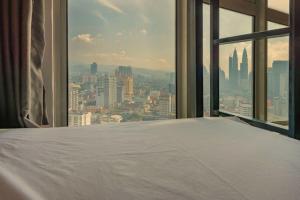 a bed in a room with a view of a city at Penthouse on 34 - The Highest Unit and Best Views in Regalia & Private Rooftop Terrace in Kuala Lumpur