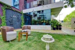 a yard with two chairs and a table in front of a building at Elite Homes in Aurangabad